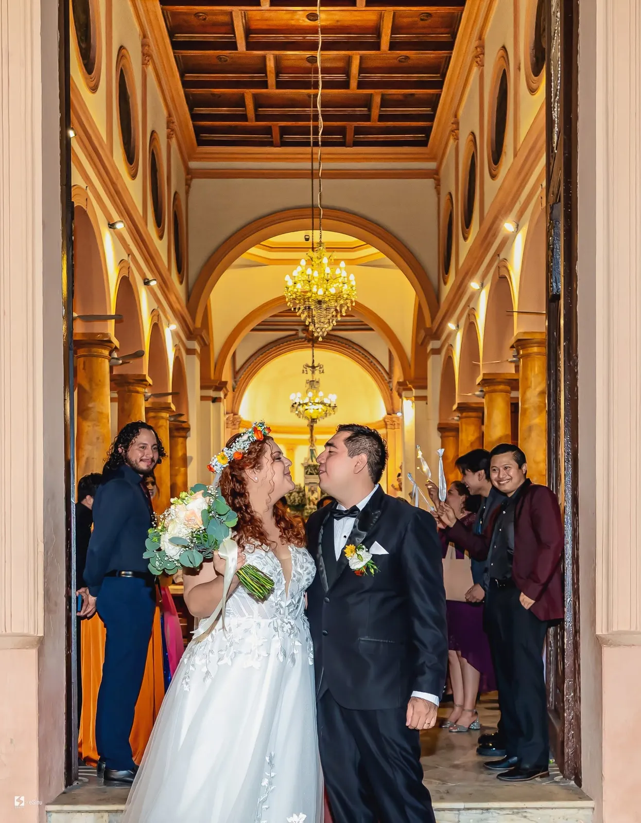 Novios en la puerta de la iglesia rodeados de sus invitados